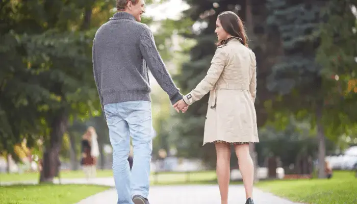 Couple walking outdoors holding hands